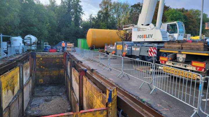 Chantier de travaux publics avec une tranchée sécurisée par un blindage métallique